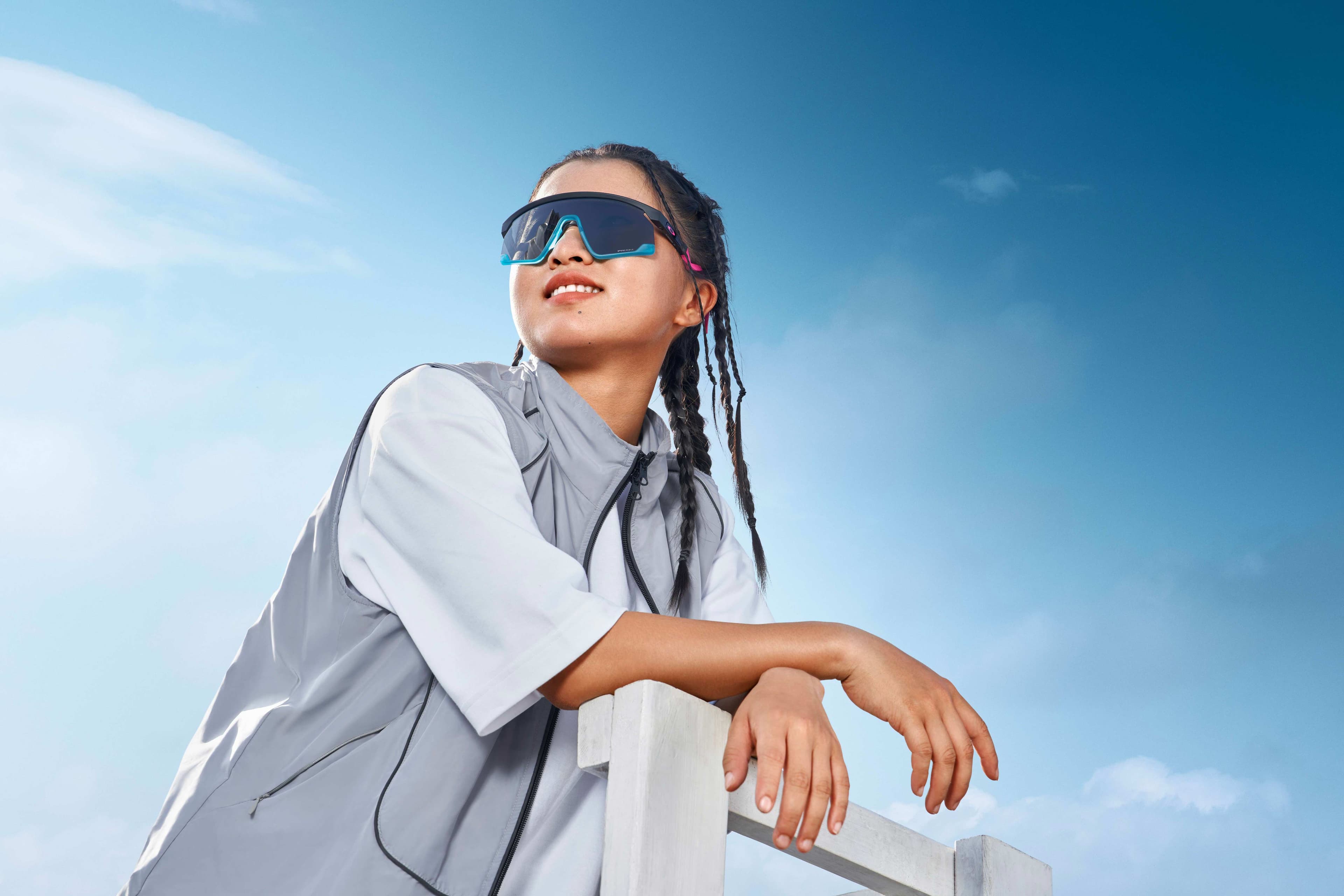 Oakley lifestyle campaign with athlete in blue sport sunglasses and windbreaker against sky by Una Zhu