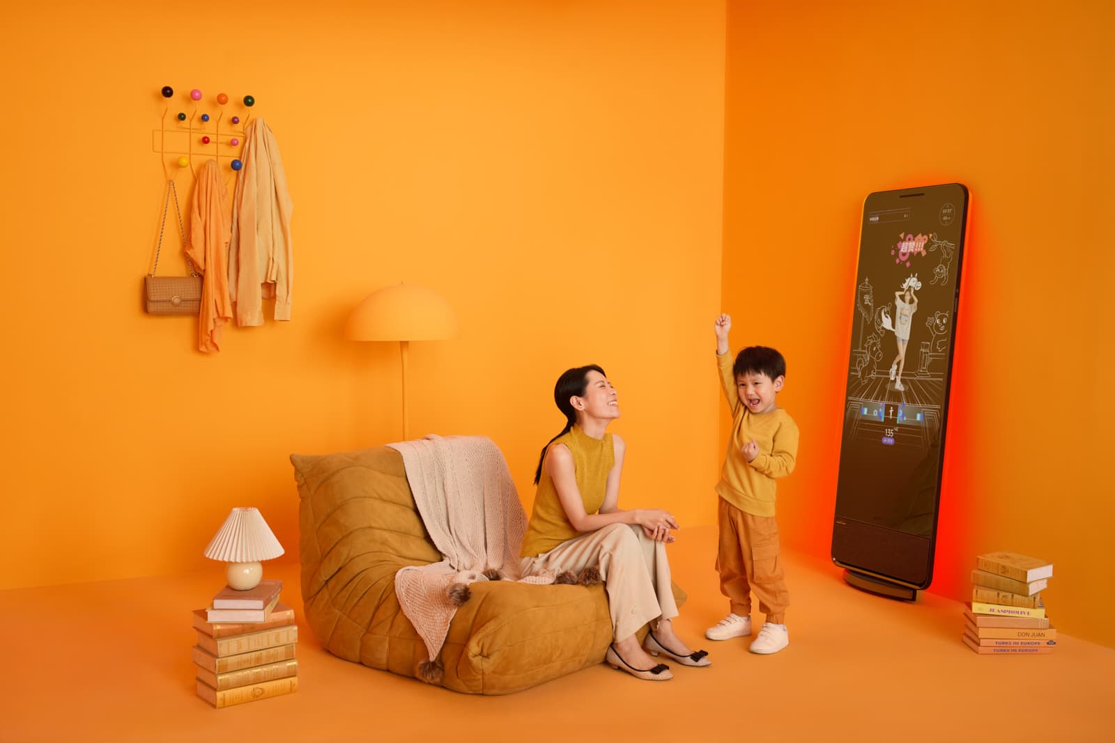 Lifestyle tech product campaign with mother and toddler in styled orange room with smart mirror by Una Zhu
