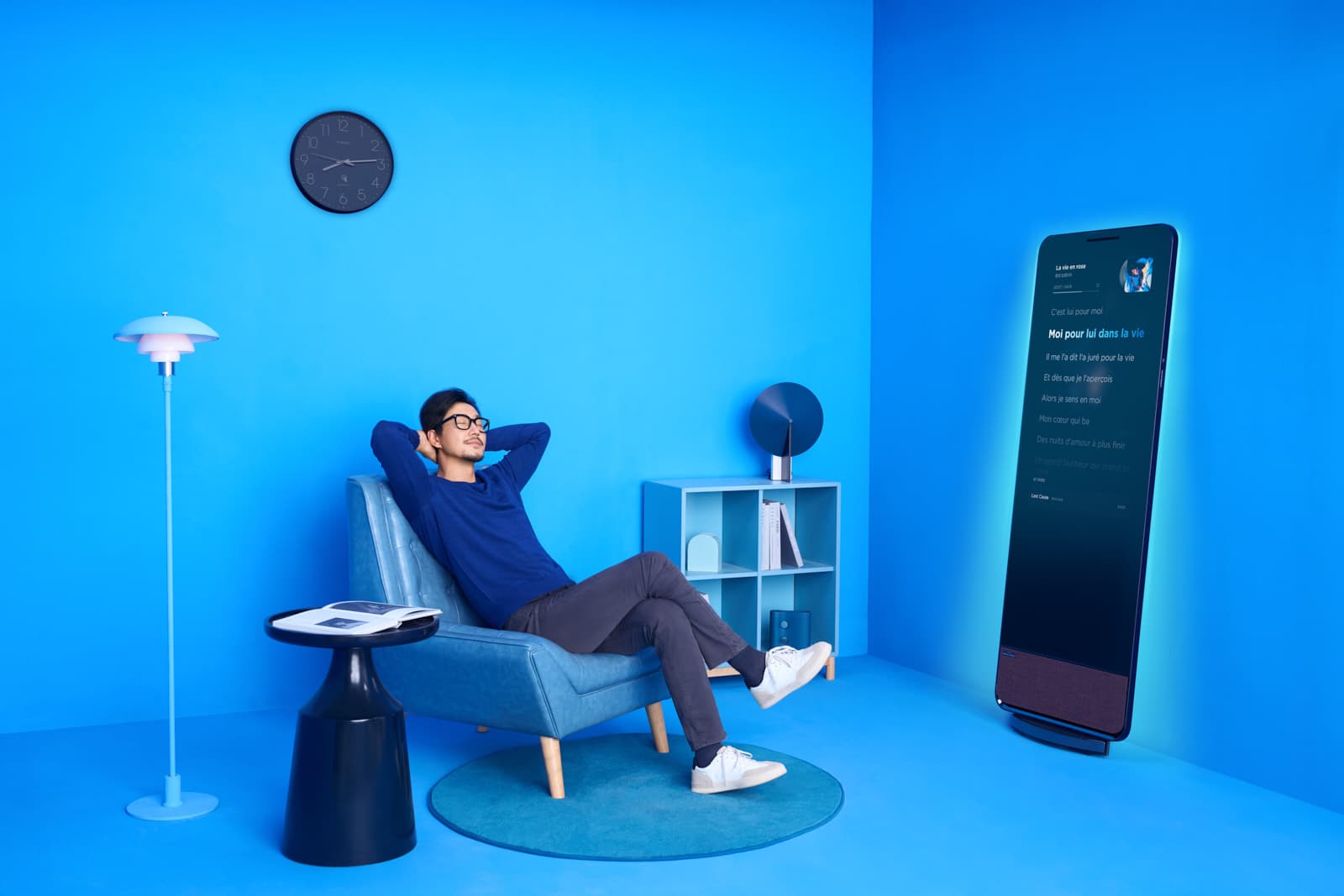 Lifestyle brand campaign with man relaxing in styled blue living room with smart music display by Una Zhu