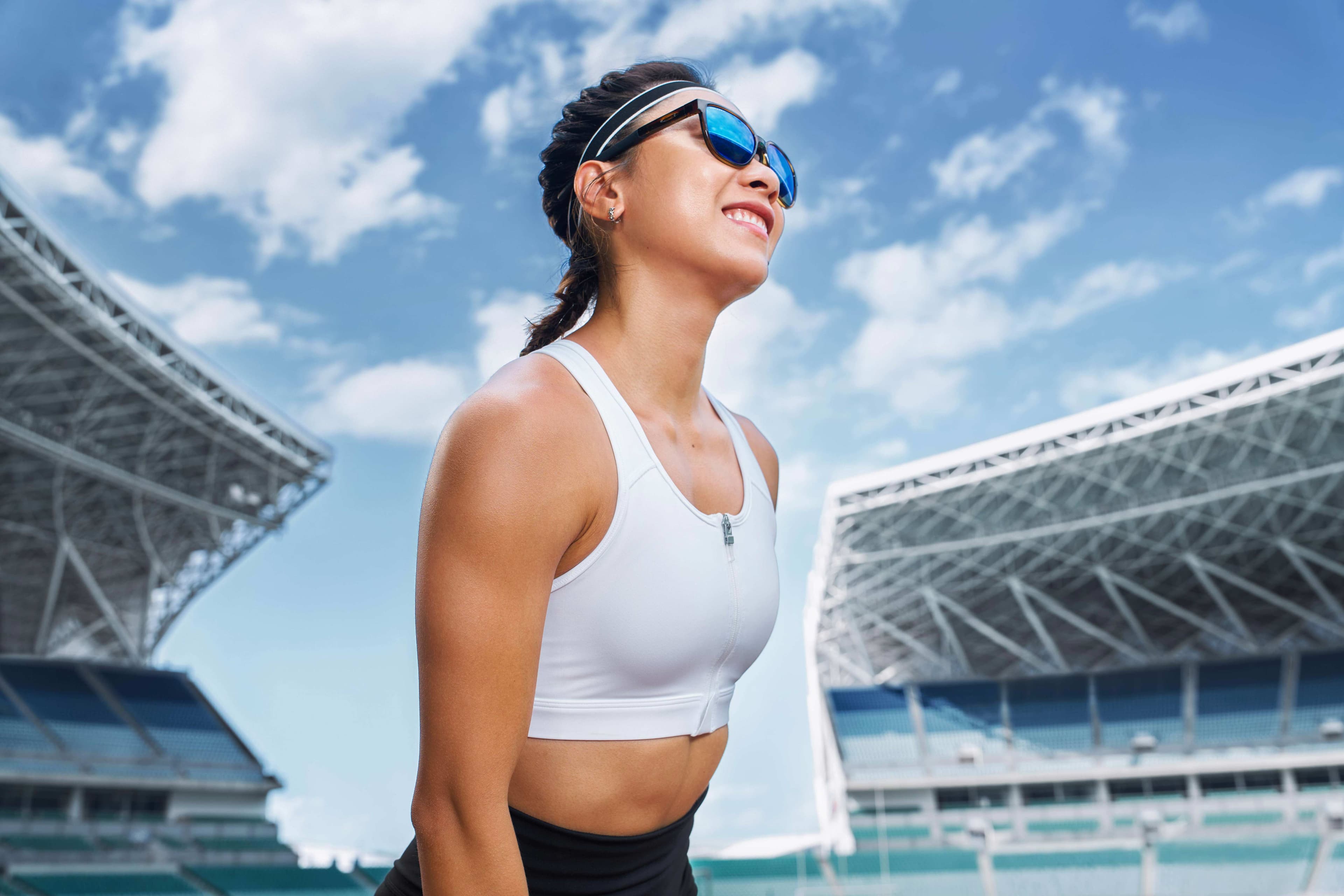 Oakley sportswear lifestyle campaign with athlete smiling at stadium wearing sport sunglasses by Una Zhu