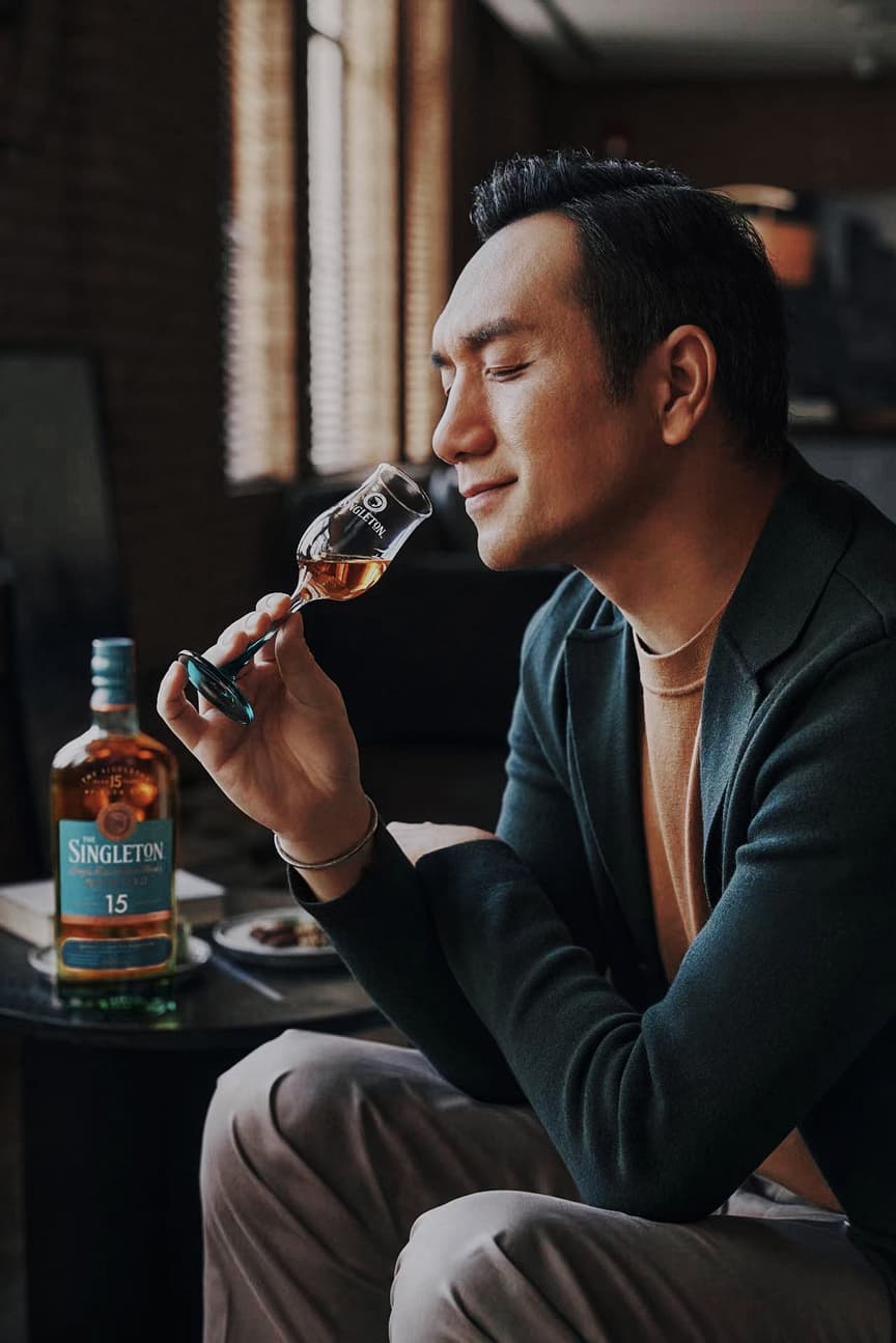 Whisky brand editorial photography with man nosing Singleton glass in natural light lounge by Una Zhu