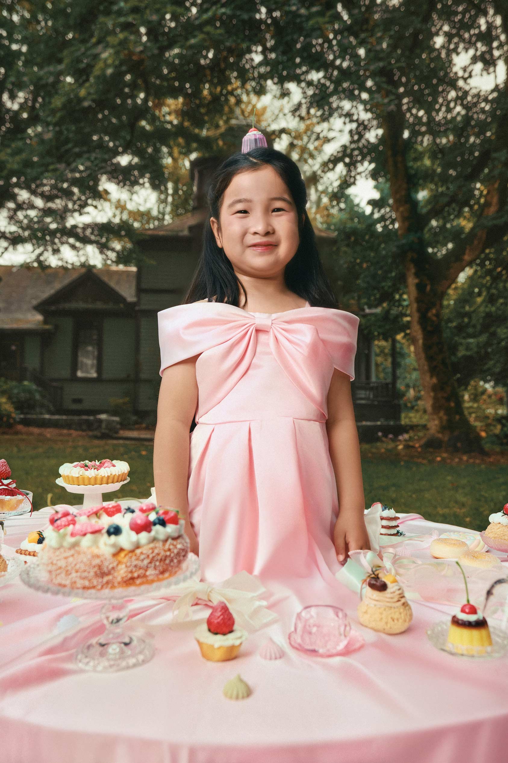 Commercial children clothing campaign with child model in pink dress at garden party by Una Zhu